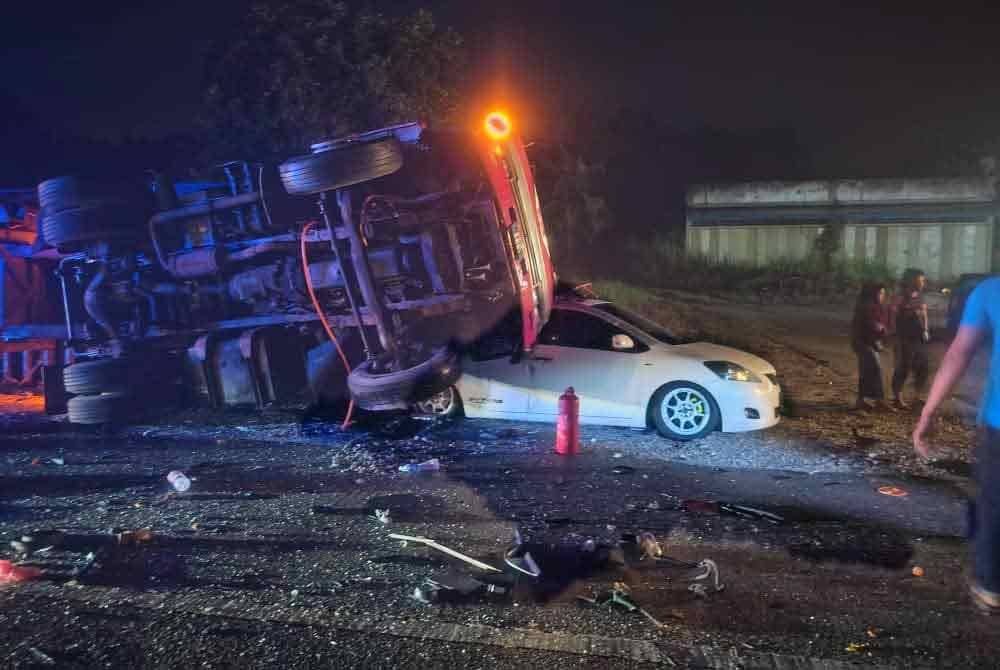 Sebuah treler yang berhenti di tepi jalan telah melanggar kereta selepas kenderaan itu dirempuh treler simen dalam kejadian di Titi Gantung pada Sabtu. Foto: ihsan Pplis