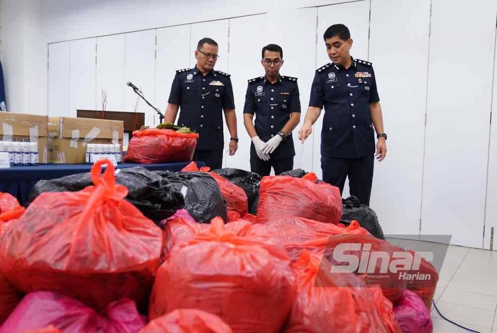 Ku Mashariman (kanan) melihat daun ketum yang dirampas. Foto Sinar Harian/MOHD HALIM ABDUL WAHID