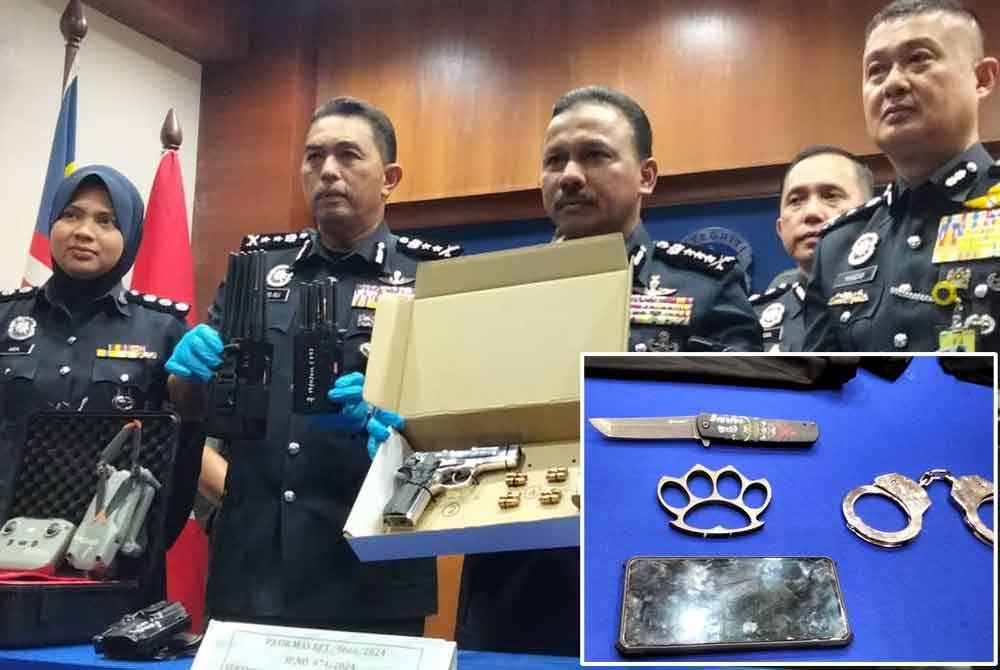 Mohd Yusoff (tiga, kiri) menunjukkan pistol yang dirampas daripada suspek pertama