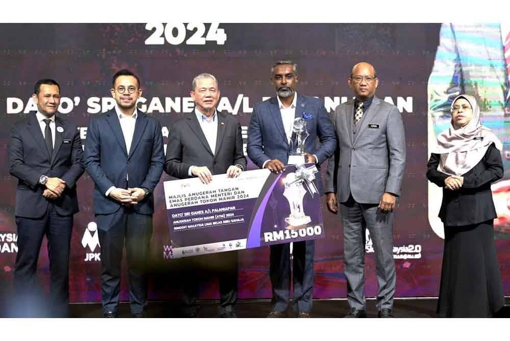 Fadillah (tiga dari kiri) menyampaikan replika cek kepada Sri Ganes pada Majlis Anugerah Tangan Emas Perdana Menteri dan Anugerah Tokoh Mahir 2024 di Putrajaya, baru-baru ini.