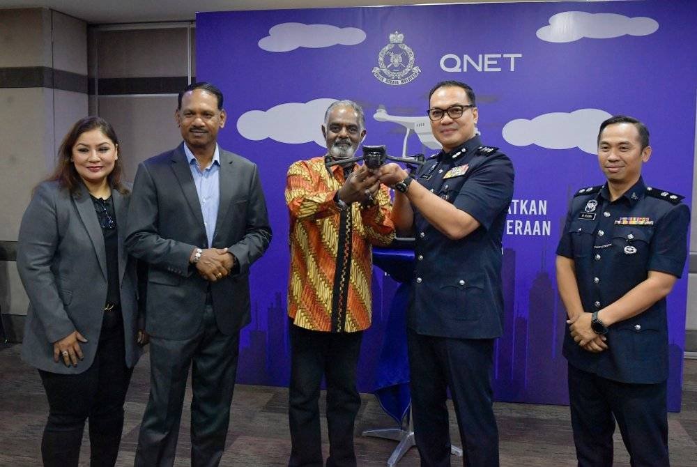 Krishna (tiga, kiri) menyerahkan dron pemantauan keselamatan kepada Shahrulnizam (dua, kanan) pada Program Kerjasama Teknologi Untuk Meningkatkan Keselamatan dan Kesejahteraan Warga Petaling Jaya di Qi Tower pada Isnin. Foto Bernama