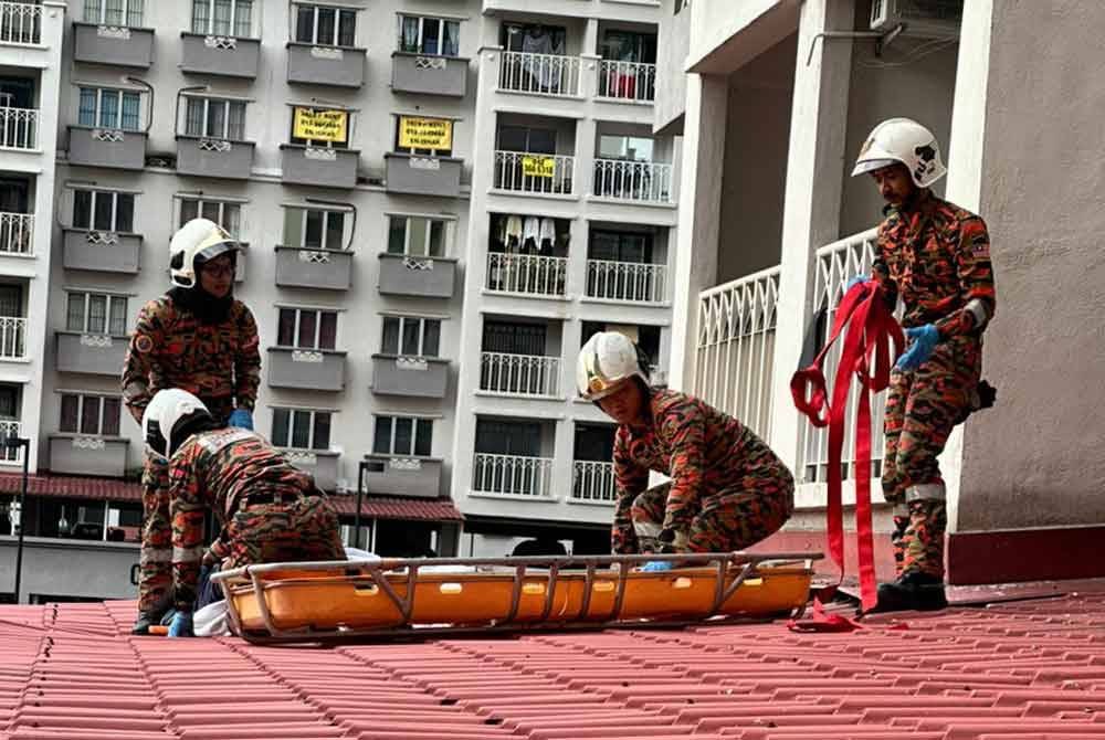 Anggota bomba menjalankan usaha menurunkan mangsa yang terjatuh di sebuah apartment pada Selasa.