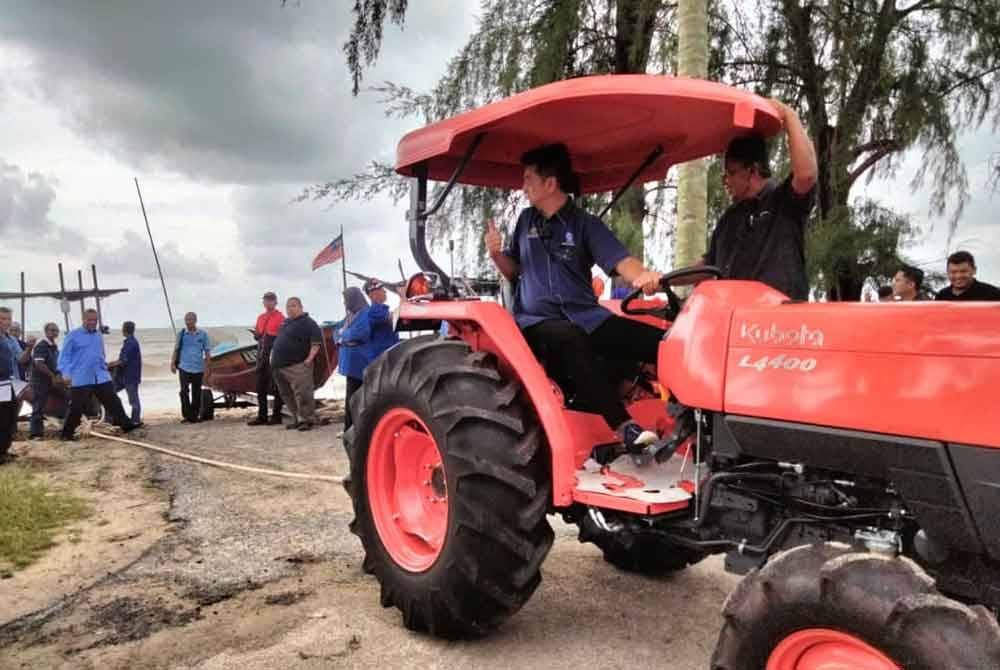 Muhammad Faiz memandu traktor untuk menarik bot selepas Majlis Penyerahan Traktor Di Bawah Program Mekanisasi Automasi 2024 Dan Penyampaian Program Industri Asas Tani pada Selasa.