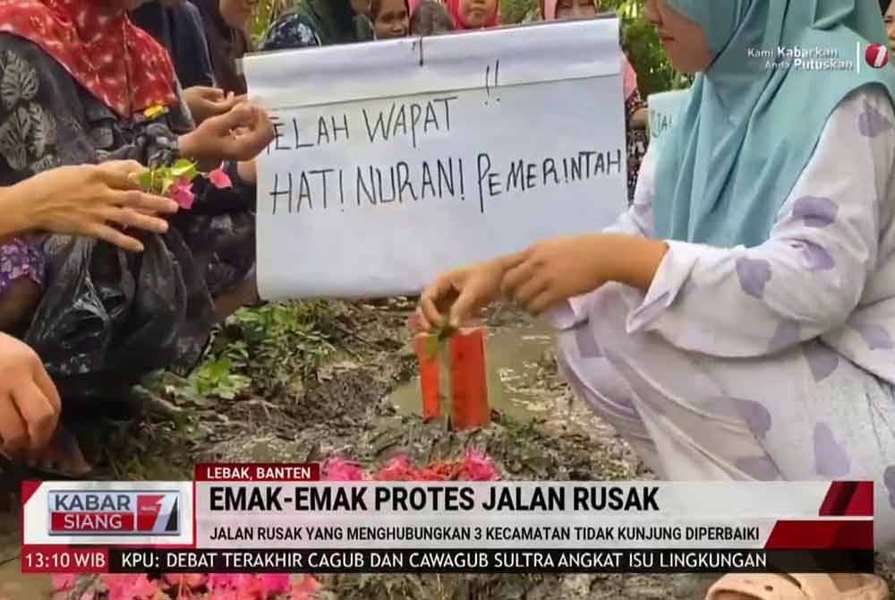 Penduduk membawa sepanduk tertulis &#039;telah wafat hati nurani pemerintah&#039; selepas selesai &#039;membina&#039; kubur di kawasan jalan rosak. Agensi