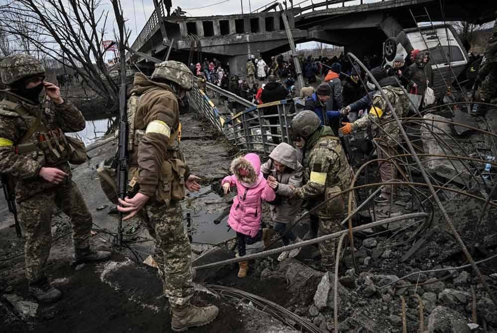 Orang awam dipindahkan melalui jambatan yang musnah dibedil di barat laut Kiev pada fasa awal peperangan tersebut.