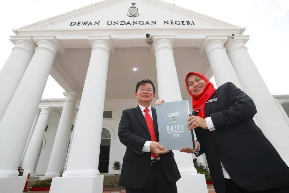 Kon Yeow bersama Pegawai Kewangan Negeri Pulau Pinang, Datuk Zabidah Safar menunjukkan dokumen Belanjawan Pulau Pinang 2025 di hadapan bangunan Dewan Undangan Negeri Pulau Pinang.