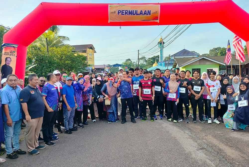 Ahmad (tengah) bergambar bersama peserta Larian Kampungku di Kampung Lubok Sipat, Benut pada Sabtu.