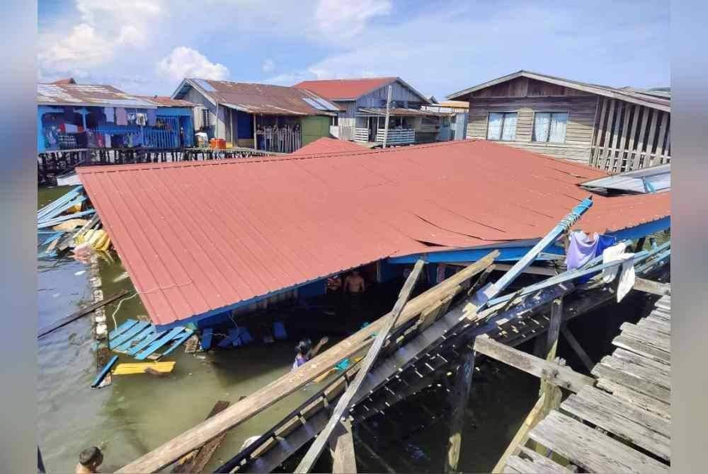 Keadaan rumah yang didiami sembilan sekeluarga roboh dan tenggelam dalam air dalam kejadian di Kampung Air, Semporna.