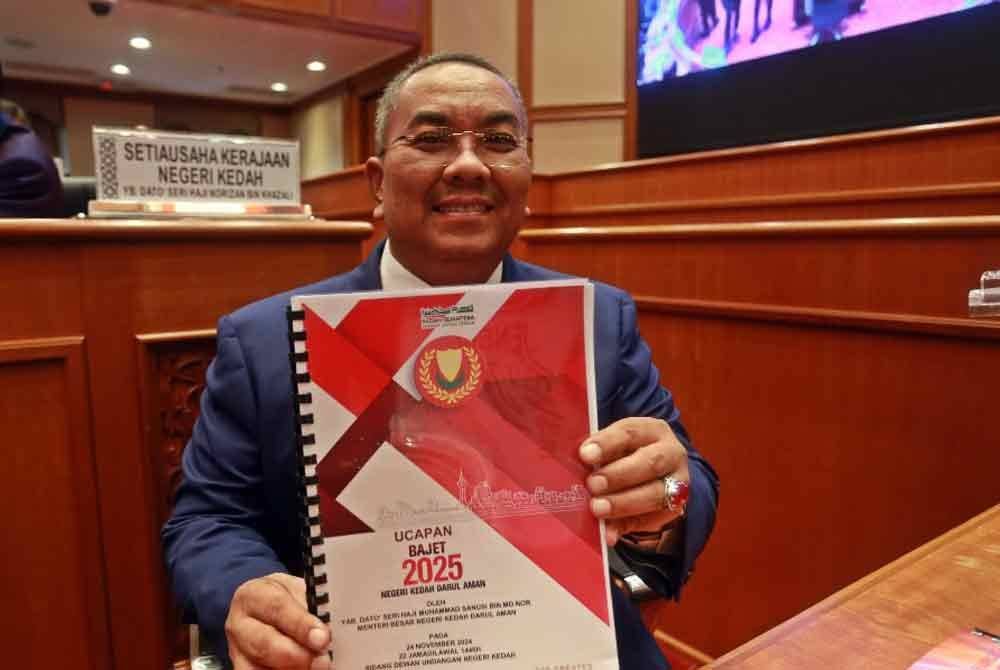 Muhammad Sanusi menunjukkan buku Belanjawan Kedah 2025 di DUN Kedah, Wisma Darul Aman pada Ahad.