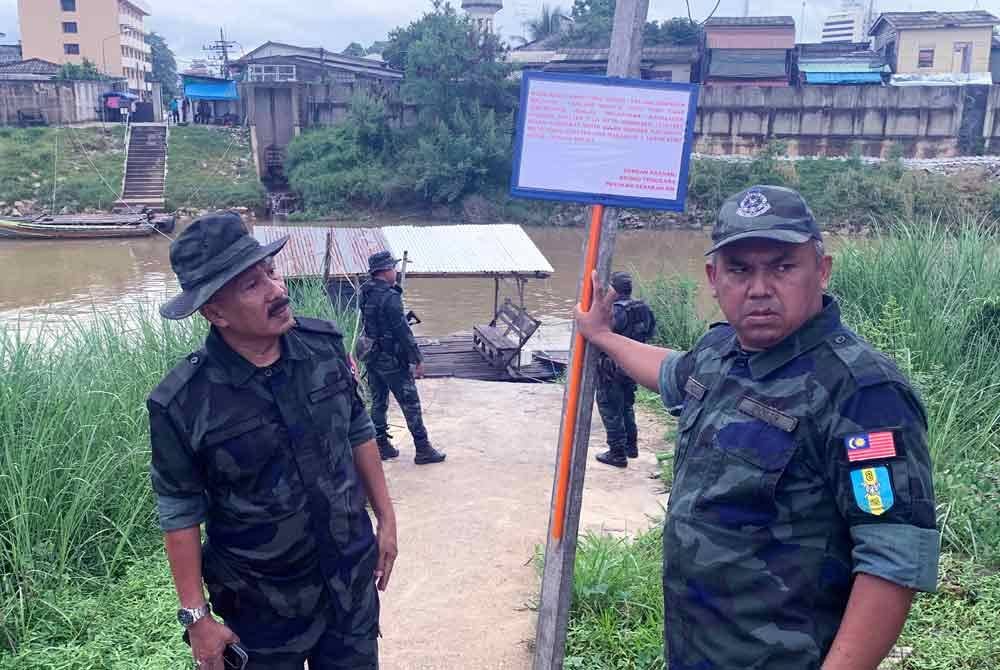 Anggota PGA memasang papan tanda peringatan kepada orang ramai supaya jangan menyeberang sempadan melalui Sungai Golok berdekatan pangkalan haram MCA dan Syed Agil, Rantau Panjang pada 21 November lalu. Foto Bernama