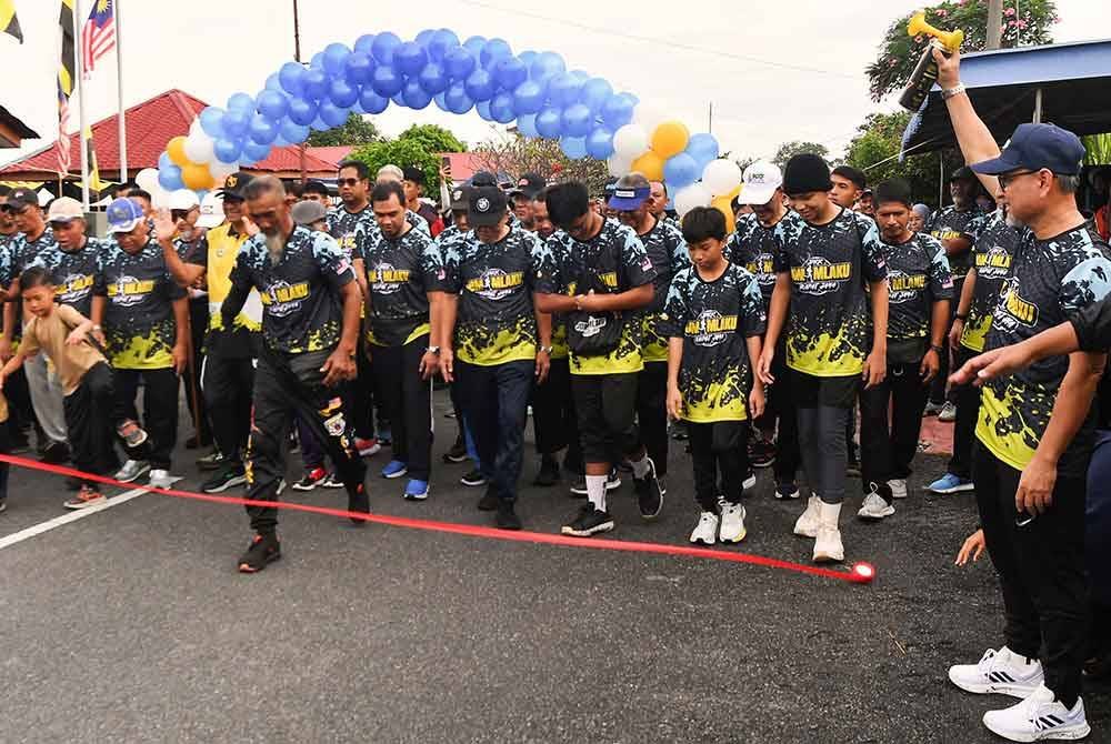 Mohd Jamil (kanan) bergambar bersama penduduk sebelum melepaskan para peserta &#039;Fun Run&#039; sejauh tiga kilometer pada Program Santuni Madani &#039;Satu Kampung, Satu Pemimpin&#039; di Kampung Rapat Jaya hari ini. - Foto: Bernama