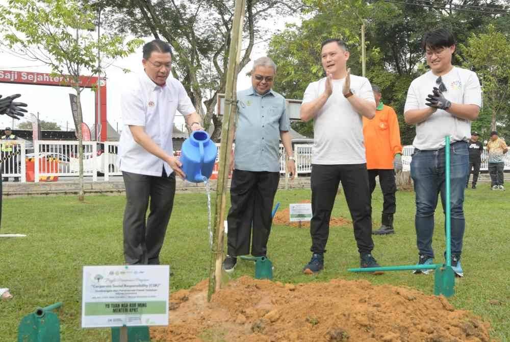 Kor Ming (kanan) ketika menyempurnakan Majlis Perasmian Penanaman Pokok CSR Wei Dat Steel Wire Sdn Bhd di Taman Rekreasi Sultan Abdul Aziz pada Ahad.