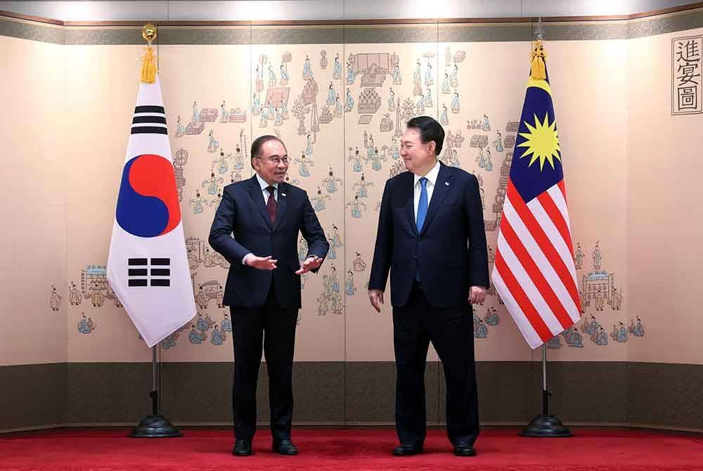 Anwar (kiri) beramah mesra dengan Yoon Suk Yeol sebelum menyaksikan pertukaran MOU dalam lawatan rasmi ke Korea Selatan di sini, hari ini. - Foto: Bernama