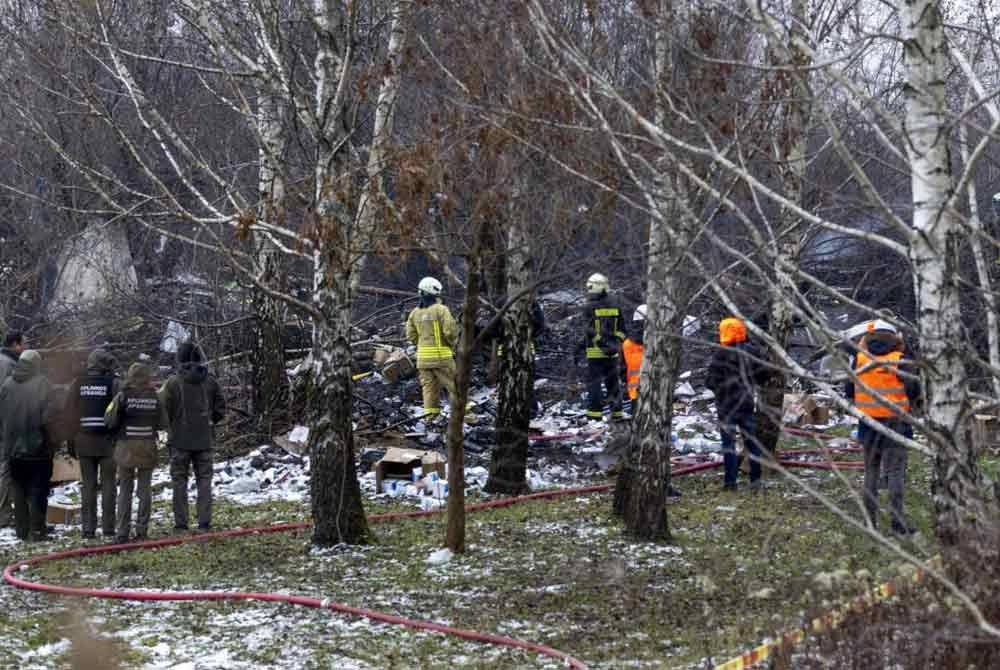 Kakitangan kecemasan Lithuania melakukan kerja-kerja menyelamat di lokasi nahas berhampiran lapangan terbang Vilnius pada pagi Isnin - Foto: AP