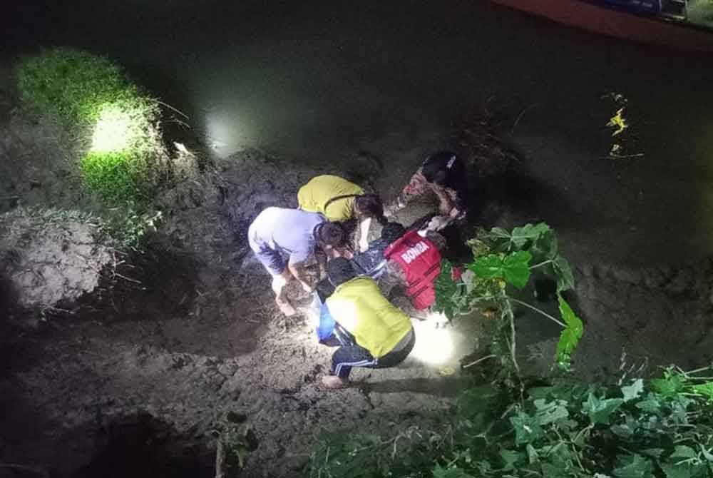 Penduduk kampung dan pasukan bomba membawa mayat mangsa keluar selepas ditemui terapung di sungai Kampung Kampung Lebak Moyoh Kupang, Kota Belud.