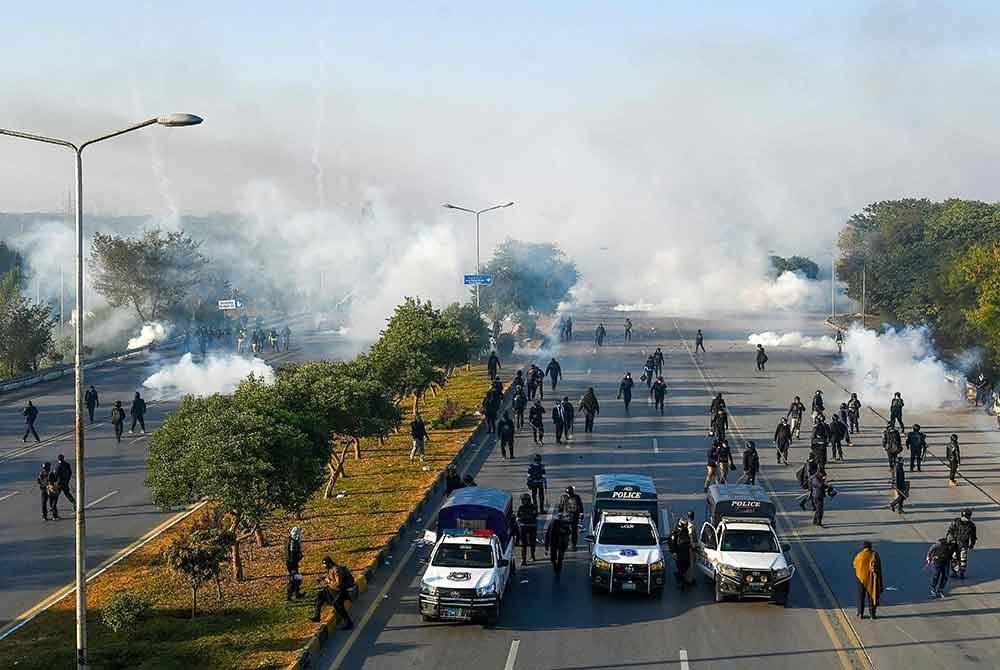 Anggota polis melepaskan peluru gas pemedih mata untuk menyuraikan penyokong parti Tehreek-e-Insaf (PTI) Pakistan semasa protes menuntut pembebasan Imran Khan di Islamabad pada Selasa. Foto AFP