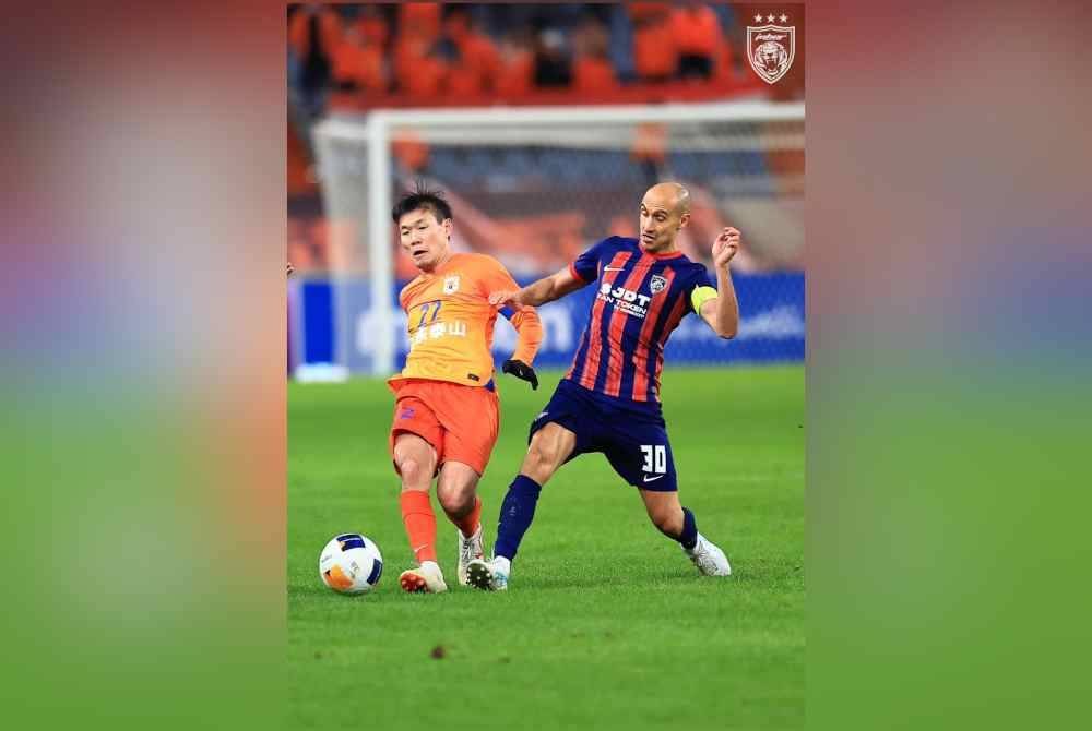 Kapten JDT, Natxo Insa cuba mengekang pemain tengah Shandong, Li Yuanyi dalam aksi Zon Timur ACLE di Stadium Olimpik Jinan. Foto Johor Southern Tigers