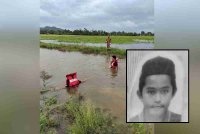 Anggota bomba ketika usaha mencari mangsa di tali air Kampung Padang Lati pada Selasa. Gambar kecil: Syamil