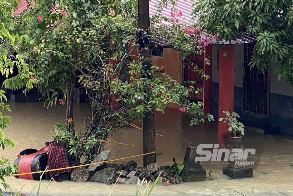 Lokasi di mana seorang mekanik ditemukan maut dipercayai terkena renjatan elektrik selepas terpegang jeriji besi pintu rumahnya yang ditenggelami banjir di Kampung Banir Belikong, Selising, Pasir Puteh pada Rabu. Foto SINAR HARIAN