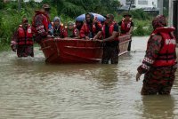 Anggota Bomba dan Penyelamat Malaysia Kelantan membawa keluar keluarga yang terperangkap selepas kediaman mereka dinaiki air susulan hujan lebat sejak semalam ketika tinjauan foto bernama di Taman Aspek, Tunjong pada Rabu. Foto Bernama