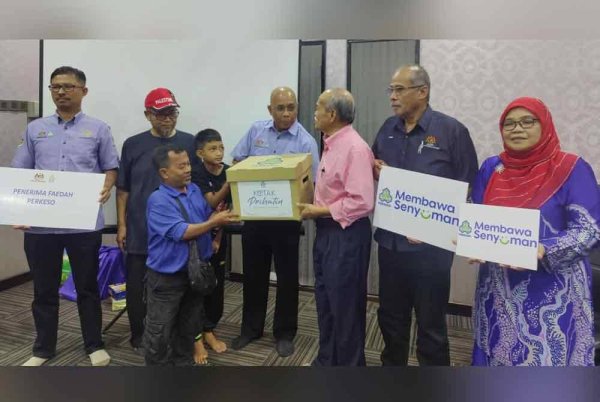 Ismail (empat dari kiri) menyerahkan kotak prihatin kepada Awang (depan tiga dari kiri) semasa penyampaian di Pejabat UMNO Bahagian Kuala Selangor pada Rabu.