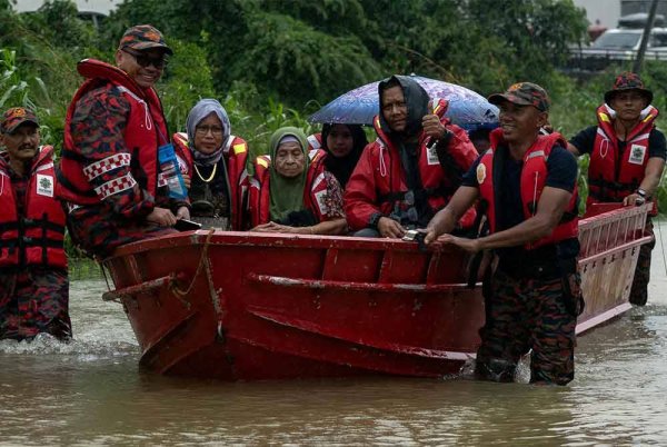 Anggota Bomba dan Penyelamat Malaysia Kelantan membawa keluar keluarga yang terperangkap selepas kediaman mereka dinaiki air susulan hujan lebat sejak semalam. Foto Bernama