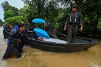 Anggota Angkatan Tentera Malaysia (ATM) dibantu penduduk melakukan operasi memindahkan mangsa banjir Zainab Mat Dhari, 76, yang terlantar sakit di Kampung Kuala Nal hari ini. Foto Bernama