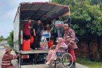 Bomba membantu memindahkan warga emas dan wanita koma bersama katil menaiki jentera bomba ke PPS di Masjid Hadhari, Jertih di Besut.