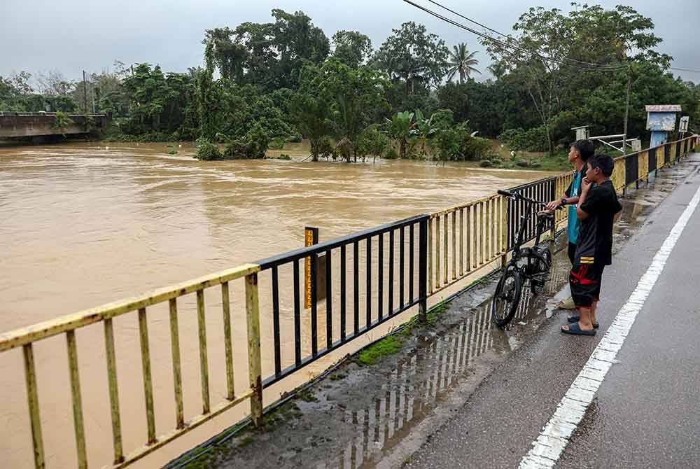 Paras air yang tinggi di Sungai Air Lanas menyebabkan kerisauan dalam kalangan penduduk di Blok Tanah Merah Jeli. - Foto: Bernama