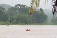 Seorang penunggang motosikal dihanyutkan arus banjir ketika melalui lokasi kejadian. - Foto tular di media sosial