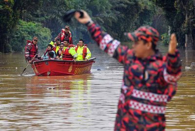 Anggota JBPM menggunakan bot bagi menyelamatkan mangsa banjir berhampiran Simpang Jelai, Jalan Tampin-Gemas pada Jumaat. Foto Bernama