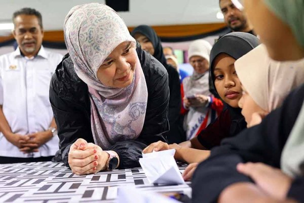 Fadhlina (dua dari kiri) bertanyakan khabar kepada mangsa banjir yang ditempatkan di PPS Sekolah Kebangsaan Demit, pada Jumaat. Foto Bernama