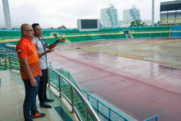 Fadzli (kiri) diberi penerangan oleh Pengurus Perbadanan Stadium Darul Makmur Izad Zainal Muhammad Safian tentang fasa akhir kerja-kerja penanaman rumput jenis Bermuda Tifgrand menggunakan keratan akar (stolon) yang telah mula dilakukan di Stadium Darul Makmur, pada Jumaat. Foto Bernama