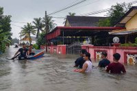 Penduduk memantau keadaan banjir di sekitar tempat tinggal mereka berikutan hujan berterusan sejak beberapa hari lepas di Kampung Lati hari ini. Foto Bernama