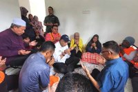 Ahmad Zahid (tengah) melawat keluarga mangsa tanah runtuh yang tinggal sementara di sebuah rumah sewa di Kampung Bukit Apit, Ajil di Hulu Terengganu pada Sabtu.