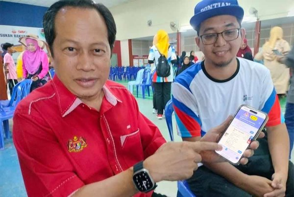 Ahmad (kiri) menunjukkan laman web http://bencanaalam.jkr.gov.my yang boleh diakses orang ramai untuk mengetahui lokasi banjir di seluruh negara.