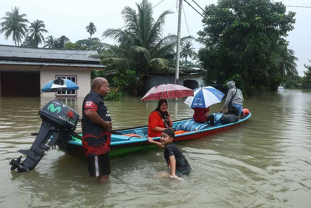 Penduduk kampung mengunakan perahu sebagai alat pengangkutan untuk melakukan aktiviti harian selepas kebanyakan kawasan dinaiki air ekoran banjir yang melanda, ketika tinjauan pada Sabtu. - Foto Bernama