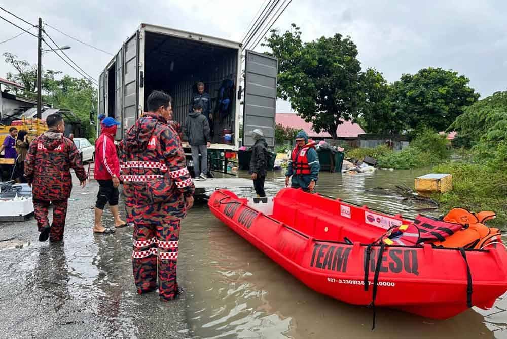 ResQ Team bersama anggota bomba memindahkan mangsa banjir.