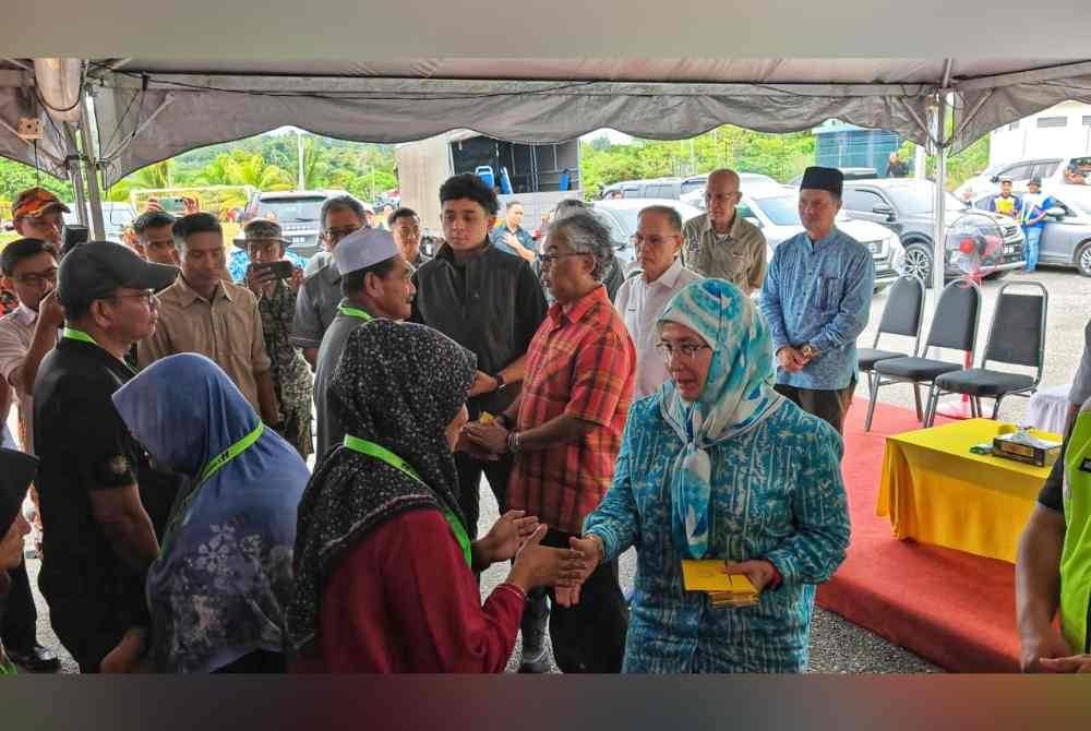 Al-Sultan Abdullah, Tunku Azizah dan Tengku Hassanal menyampaikan sumbangan kepada mangsa banjir di Dewan Kampung Lechar di Raub pada Ahad.