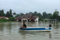 Penduduk kampung mengunakan perahu sebagai alat pengangkutan untuk melakukan aktiviti harian selepas kebanyakan kawasan dinaiki air ekoran banjir yang melanda. Foto Bernama