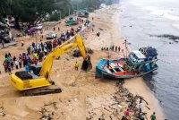 Nelayan serta penduduk kampung bergotong-royong mengalihkan bot nelayan yang dihanyutkan oleh fenomena ombak besar tengah malam tadi ketika tinjauan di Kampung Telaga Papan, hari ini. Foto Bernama