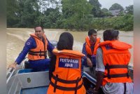 APM membantu 95 pelajar SMK Keroh di sini menyeberang Sungai Kuala Nal untuk pulang ke rumah masing-masing hari ini. Foto FB APM Kuala Krai