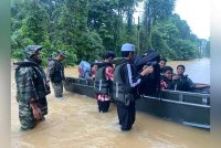 ATM membantu memindahkan calon SPM setelah pusat peperiksaan di SMK Menerong dinaiki air. Foto ATM