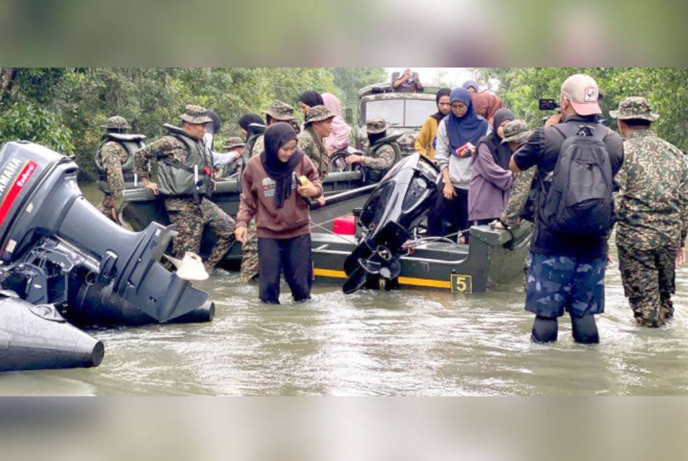 Calon-calon SPM meredah banjir sedalam 0.4 meter sebelum menaiki bot sehingga ke Padang Licin, Rantau Panjang, Kelantan.