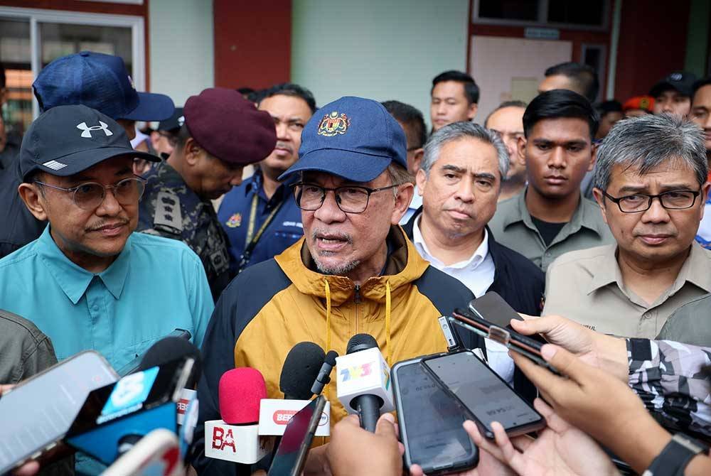 Anwar (tengah) semasa melakukan lawatan di PPS Sekolah Kebangsaan Telaga Papan, Bandar Permaisuri pada Ahad. Foto Bernama