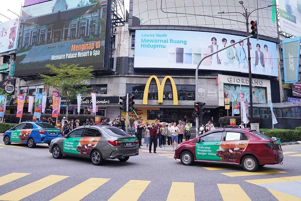 30 Grabcar berarak dengan replika beg kertas McDonalds di atas bumbung pada Pelancaran Burger Prosperity di McDonald’s Bukit Bintang pada Isnin. Foto Sinar Harian/MOHD HALIM ABDUL WAHID