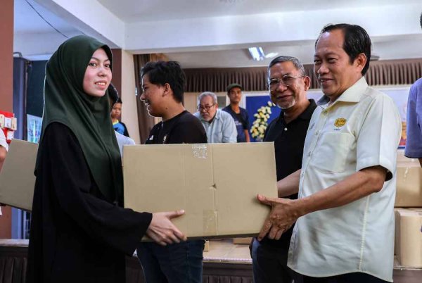 Ahmad menyampaikan bantuan barangan keperluan harian kepada mangsa banjir yang tinggal di PPS Sekolah Kebangsaan Kubang Batang, pada Isnin. Foto Bernama