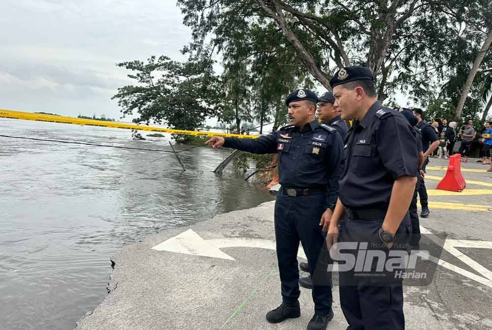 Mohd Yusoff (kiri) turun padang meninjau jalan yang rosak akibat banjir di Tumpat.