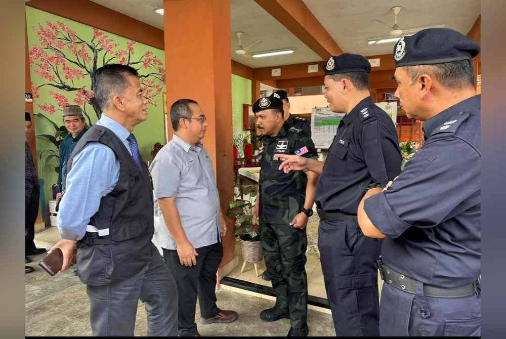 Dr Zaini (kiri) turut hadir ke PPS Sekolah Kebangsaan Padang Pohon Tanjung melawat mangsa banjir.