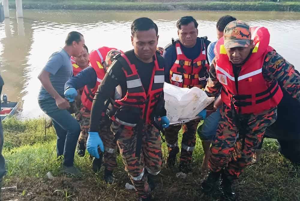 Anggota bomba dan penyelamat mengangkat mayat pengawal keselamatan yang ditemukan lemas selepas hanyut ketika memukat ikan. Foto ihsan JBPM Kedah